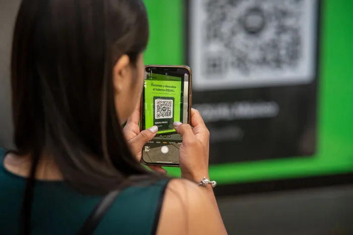 Une personne scanne un QR code avec l'appareil photo de son téléphone.